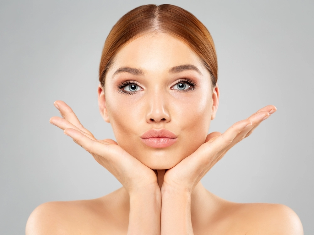 Woman showcasing the common treatment areas for Sculptra injection, including cheeks and jawline.
